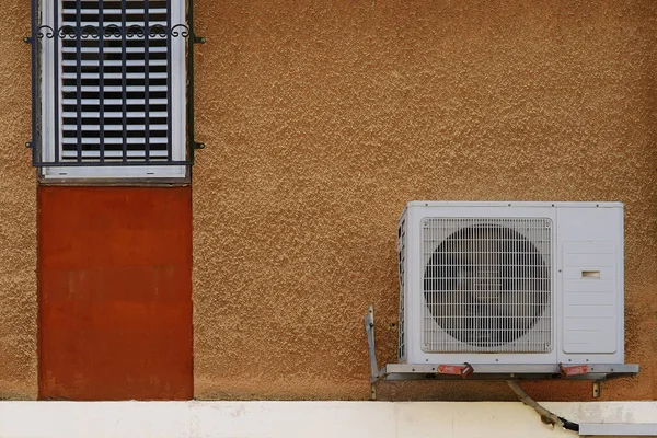 Air conditioner on the street wall of the residential house. On the facade of residential building white air conditioner. Concept of indoor climate and air circulation