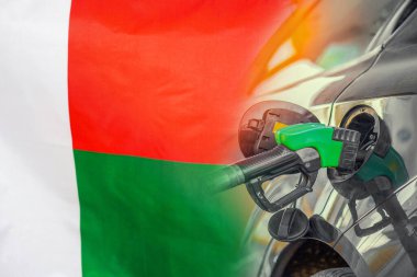 Madagaskar bayrağı arka planında yakıt enjektörü olan bir araba. Nüfus için rekor fiyatlar yakıt. Madagaskar 'daki enerji ve akaryakıt krizi sırasında benzin fiyatları arttı