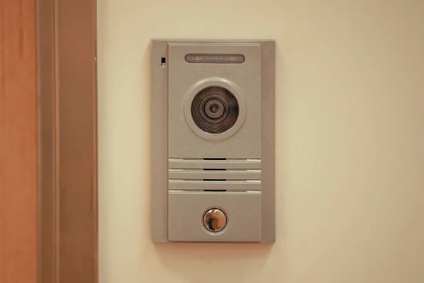 Video intercom system on white wall to enter office. Intercum with a camera in the office. New video intercom. Video intercom display on white wall near the entrance door