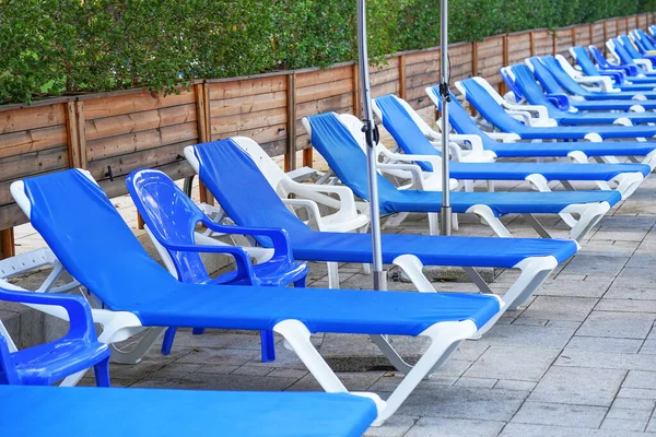 Closeup Row Blue Plastic Empty Sun Loungers Pool Empty Sunbeds — Fotografia de Stock