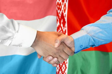 Business handshake on background of two flags. Men handshake on background of Luxembourg and Belarus flag. Support concept