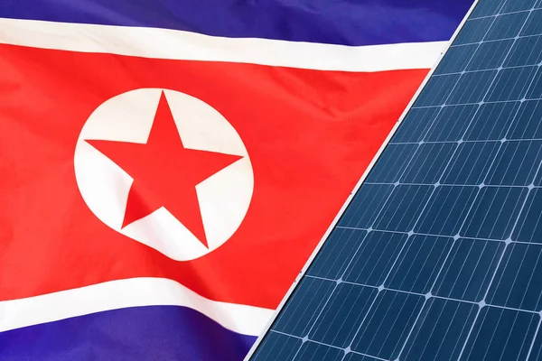 Solar panels against flag North Korea background. Solar battery generates a pure electricity. Concept of sustainable resources and renewable energy in North Korea