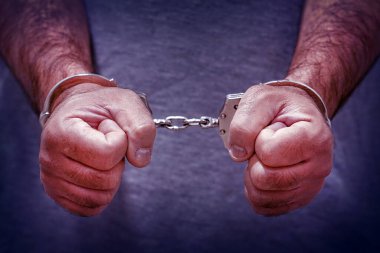 Handcuffed hands in front. Arrested criminal man with handcuffs