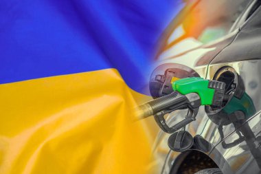 Car with a fuel injector on Ukraine flag background. Record prices fuel for population. Gasoline price increase during energy and fuel world crisis in Ukraine