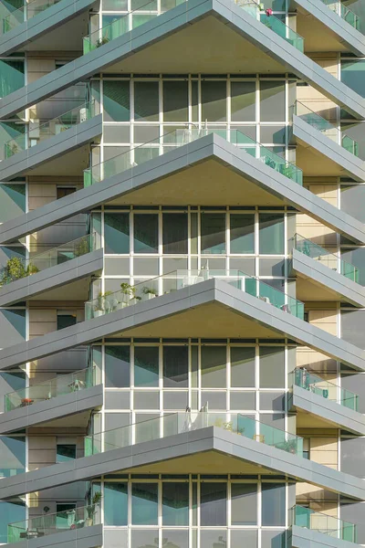 Glass green balconies windows of facade modern city building. Facade of building texture closeup