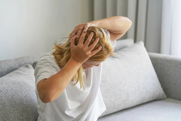 Stressed woman holding head in hands. Unhappy depressed woman suffering from disability. Concept of loneliness and loss of love. Crisis, rising prices