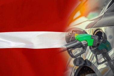 Letonya bayrağında yakıt enjektörü olan bir araba. Nüfus için rekor fiyatlar yakıt. Letonya 'daki enerji ve akaryakıt krizi sırasında benzin fiyatlarında artış