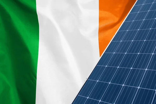 Solar panels against flag Ireland background. Solar battery generates a pure electricity. Concept of sustainable resources and renewable energy in Ireland