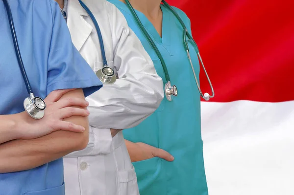 Tre Läkare Med Stetoskop Stående Indonesien Flagga Bakgrund Närbild Medicinska — Stockfoto