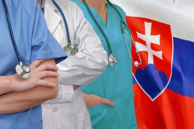 Steteskoplu üç doktor Slovakya bayrağı arkaplanında duruyor. Yakın çekim tıbbi ekip. Bir grup doktor ve hemşire. Bilim ve tıp alanında yenilikçi teknolojiler, Slovakya 'da tıbbi gelişim