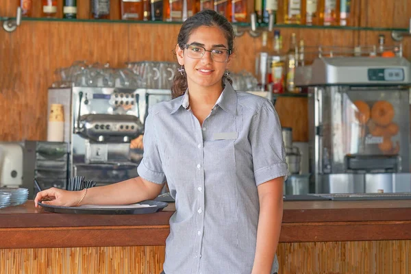 Portrait of waitress standing near the restaurant bar
