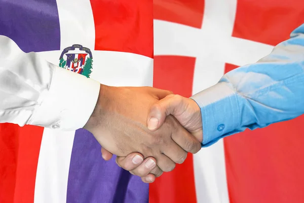 在两面旗帜的背景下进行商业握手 男子握手背景多米尼加共和国和丹麦国旗 支助概念 — 图库照片