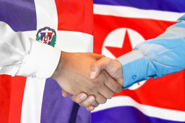 İki bayrağın arka planında iş tokalaşması. Dominik Cumhuriyeti ve Kuzey Kore bayrağının arka planında erkek tokalaşması. Destek konsepti