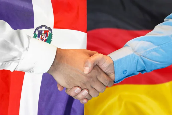 Business handshake on background of two flags. Men handshake on background of Dominican Republic and Germany flag. Support concept