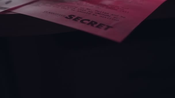 他の機密書類の横にある Top Secret というタイトルの文書を押します 暗いオフィスで機密政府や軍事機密テキストメモや論文 カバー活動又はカバーアップ — ストック動画