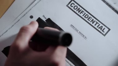 Gizli askeri belgelerdeki el redaksiyonu ve sansürleme metinlerini kapatın. El, hükümet teşkilatı veya casusluk veya gizli operasyonlar tarafından hazırlanan çok gizli rapordaki bilgileri saklamak ve sansürlemek için kara kalem kullanıyor.