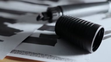 Sansürlenmiş belgeler ve karanlık masanın üzerindeki siyah işaret arasında yavaş bir hamle. Çok gizli ve gizli belgeler. İçinde gizli belgeler var. Hassas bilgiler ve kısa mesajlar. Sızdırılan ya da açığa çıkarılan