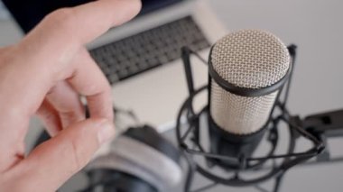 Bilgisayarın yanındaki ses kayıt cihazları - oturumdan önce mikrofonu elle kontrol eder. Video konferans ya da podcast sunucusu. Ev stüdyosunda ya da ofiste ekipmanlar hazır. Kulaklık ve dizüstü bilgisayar