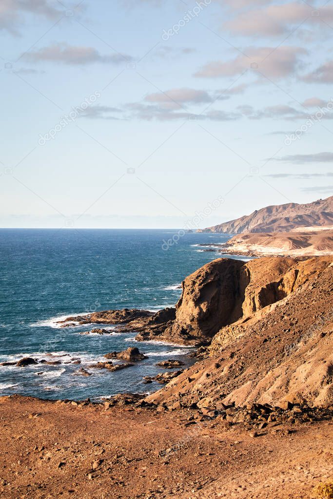 View over the rough and rocky west coast of Fuerteventura in the Atlantic Ocean with cliffs and beautiful surf of the water, Canary Islands, Spain
