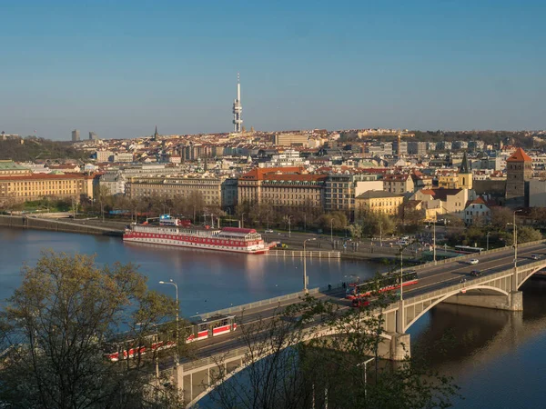 Scénický letecký pohled na střechu pražského Starého a Nového Města a most přes Vltavu s hausbótem a tramvají z Letenského vrchu, jarní slunečný den, modré nebe, Česká republika — Stock fotografie