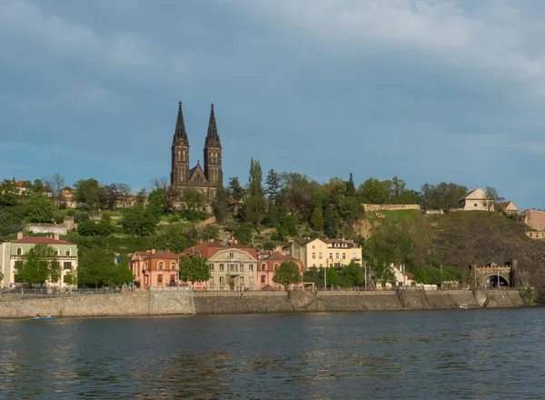 歴史的な砦を望むヴルタヴァ川の銀行聖ピーターとポール大聖堂、緑の丘と岩の上にゴシック様式の大聖堂教会、プラハ、チェコ共和国、春の日. — ストック写真