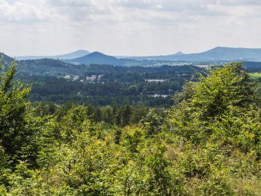 Kum taşından panoramik manzara Havrani skali, Lusatian Dağları 'ndaki bahar manzarası, yeşil tepeler, taze yaprak döken ağaçlar ve ladin ormanları. Mavi gökyüzü arkaplanı, boşluğu kopyala