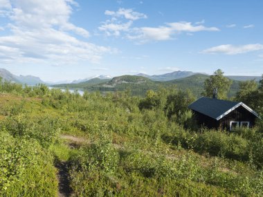 İsveç Laponya huş ormanlarındaki Saltoluokta 'da Lulealven Gölü kıyısındaki dağ kulübesi, Lule Nehri barajı. Kungsleden 'de yaz kulübesi, Kings yürüyüş patikası.