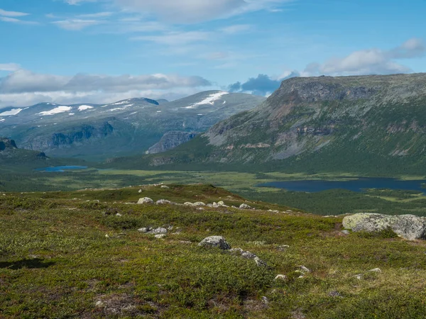 从拉帕达伦三角洲到瑞典拉普兰萨莱克国家公园的拉贾塔夫勒湖的蜿蜒曲折的风景。北欧野景,有高山、小山、岩石和桦树.夏日晴天，蓝天 — 图库照片