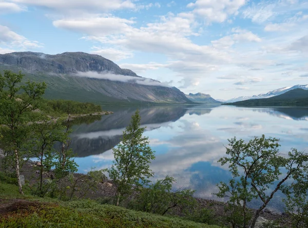 在瑞典拉普兰Saltoluokta的Lulealven湖畔美丽的早上，Lule河大坝。群山、树木和天空的映像，在清澈平静的水中，笼罩着戏剧性的云彩。北部夏季 — 图库照片