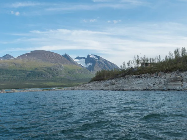 Θέα το καλοκαίρι πάνω από τη λίμνη Akkajaure να Akka, βουνό Ahkka massif με χιόνι και παγετώνα και Anonjalmme setllement saami. Αφετηρία της πεζοπορικής διαδρομής Padjelantaleden στη Λαπωνία της Σουηδίας — Φωτογραφία Αρχείου