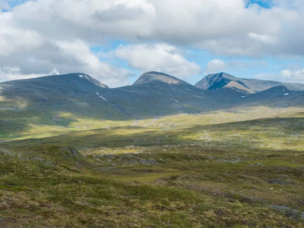 Piękny krajobraz północny krajobraz arktyczny, tundra w szwedzkiej Laponii z zielonymi wzgórzami i górami na Padjelantaleden szlaku turystycznym. Letni dzień, błękitne niebo, białe chmury — Zdjęcie stockowe