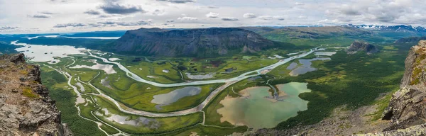 Letecký panoramatický výhled ze skalního vrcholu Skierffe na ledovcovém údolí řeky Rapadalen v národním parku Sarek s meandry, jezery, horami, břízami. Letní den krajina Švédsko Laponsko — Stock fotografie