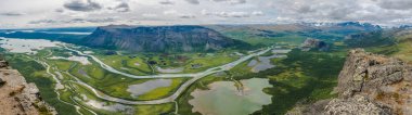 Sarek Ulusal Parkı 'ndaki buzul Rapadalen Nehri delta vadisindeki Skierffe kaya zirvesinden havadan manzaralı bir manzara. Yol kenarları, göller, dağlar, huş ağaçları. İsveç Yaz Günü manzarası
