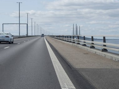 Malmo, Sweden, Agust 21, 2021: View of Oresund bridge, seen from car window. Longest road and rail bridge in Europe with an artificial island between Sweden and Denmark.