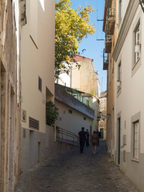 Lisbon, Portugal, October 24, 2021: View of steep narrow Lisbon streets at medieval quarter Alfama at Santa Maria Maior district