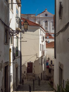 Lizbon, Portekiz, 24 Ekim 2021: Orta Çağ eski Alfama kasabasında merdivenleri olan dik, dar Lizbon Caddesi manzarası.