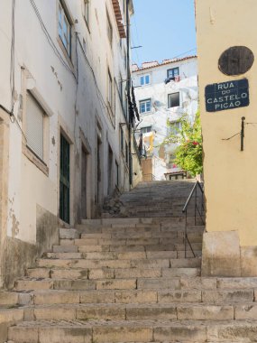 Lizbon, Portekiz, 24 Ekim 2021: Orta Çağ eski Alfama kasabasında merdivenleri olan dik, dar Lizbon Caddesi manzarası.