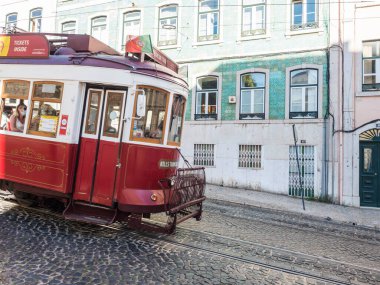 Lizbon, Portekiz, 24 Ekim 2021: Eski başkent Alfama 'nın dik, dar Lizbon caddesinde ilerleyen kırmızı turist klasik tramvayına yakından bakın
