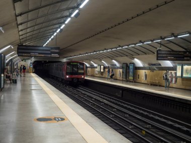 Lizbon, Portekiz, 24 Ekim 2021: Lizbon şehir merkezindeki bir metro istasyonunun tipik iç hatları trenin gelişi ve gezgin insanların yeraltı metrosuyla seyahat etmesi.