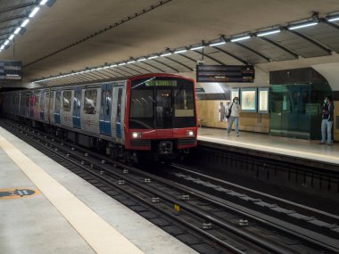 Lizbon, Portekiz, 24 Ekim 2021: Lizbon şehir merkezindeki bir metro istasyonunun tipik iç hatları trenin gelişi ve gezgin insanların yeraltı metrosuyla seyahat etmesi.