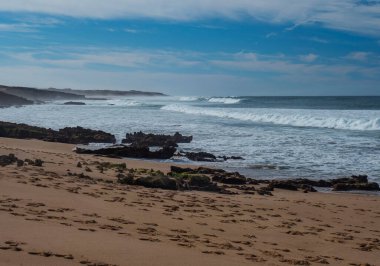 Boş Praia da Ilha do Pessegueiro kumsalı manzarası. Okyanus dalgaları ve keskin kayalar Porto Covo, Portekiz yakınlarındaki vahşi Rota Vicentina sahillerinde toplanıyor.