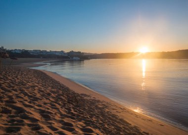 Mira nehri ve Forte de Milfonte kalesi ile Vila Nova de Milfontes 'teki boş kumsal Praia da Franquia' da turuncu gün doğumu. Portekiz, Rota Vicentina Sahili.