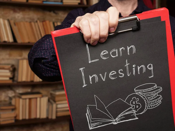 学習投資はお金と本のテキストと写真を使用して表示されます — ストック写真