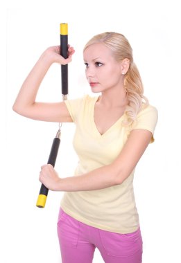 Blonde young woman with nunchaku isolated on white background