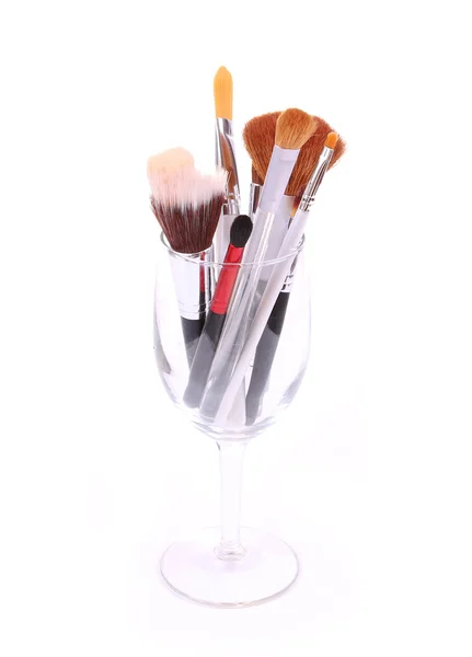 Borstels voor make-up in glas op witte achtergrond — Stockfoto