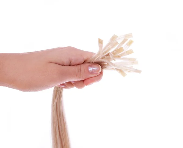 Sarı saç uzantıları üzerinde beyaz izole kadın elinde keratin kapsül