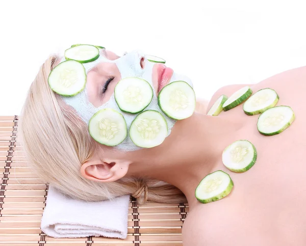 Young girl with facial mask of cucumber on bamboo mat , spa — Stock Photo, Image