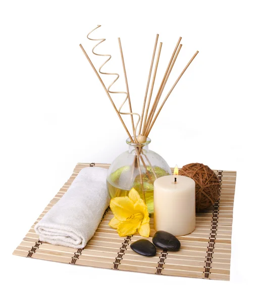 Ambiente de spa com varas de aroma, vela, flor, toalha, bola de madeira e pedras isoladas no fundo branco — Fotografia de Stock