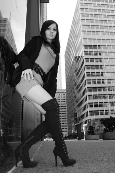 Brunette girl in sexy boots posing in the city, black and white — Stock Photo, Image