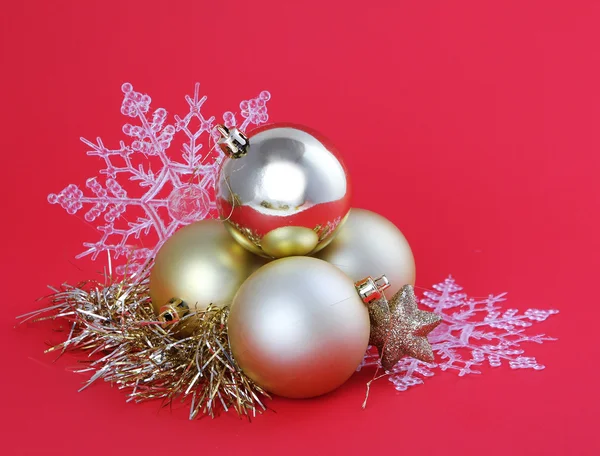 Bolas de oro de Navidad y copos de nieve sobre fondo rojo, tarjeta —  Fotos de Stock